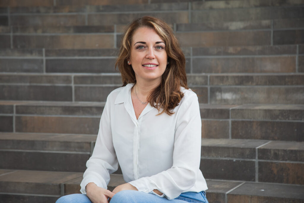 Jan Windisch, Fotograf und Hochzeitsfotograf aus Dresden, Prina, Görlitz, Großenhain und Leipzig, hat hier eine Frau fotografiert. Sie sitzt auf einer Treppenstufe und schaut in die Kamera.