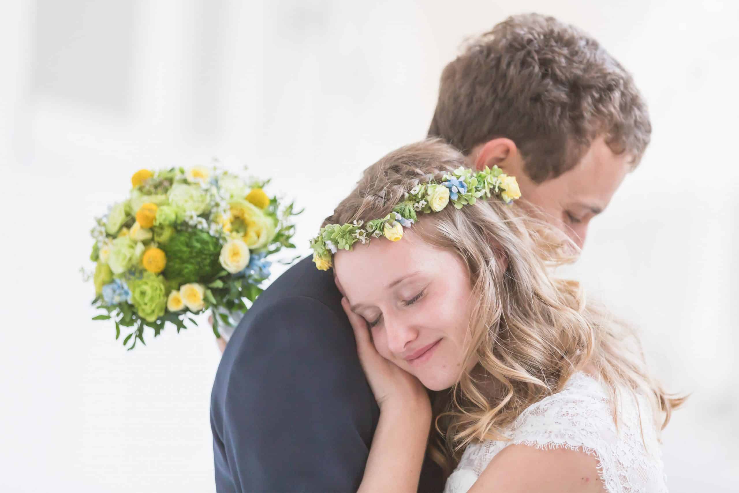 Jan Windisch, Fotograf und Hochzeitsfotograf aus Dresden, Prina, Görlitz, Großenhain und Leipzig, hat hier ein Brautpaar fotografiert. Beide sind von der Seite fotografiert und die Braut hat Ihren Kopf auf seiner Schulter abgelegt. Sie trägt einen Blumenkranz und hält einen Blumenstrauß in der gleichen Farbe in der Hand.