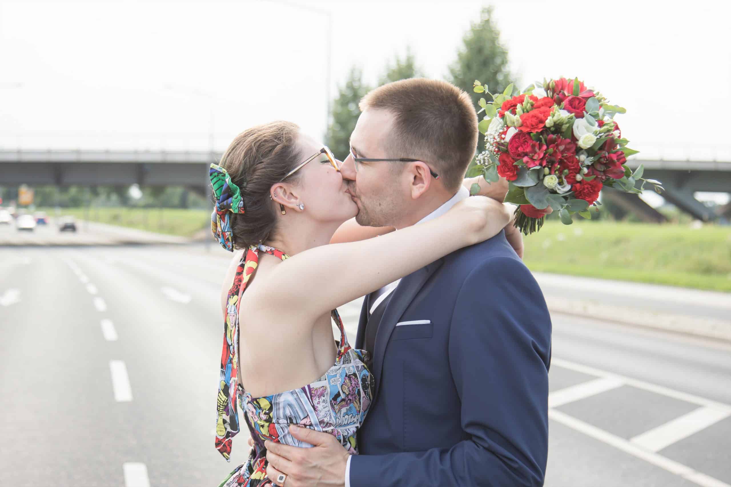 Jan Windisch, Fotograf und Hochzeitsfotograf aus Dresden, Prina, Görlitz, Großenhain und Leipzig, hat hier ein Brautpaar fotografiert. Das Paar steht nebeneinander auf einer Straße und küssen sich. Beide Personen sind ab der Hüfte aufwärts zu sehen.