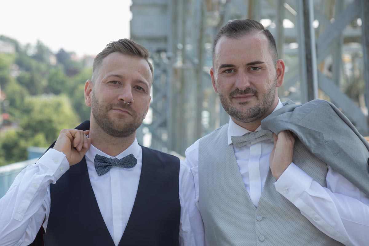 gay wedding - locker und lässig stehen die beiden Männer da und tragen ihr Sako über der Schulter