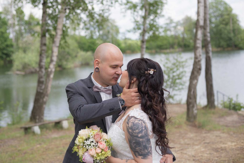 Das Brautpaar küsst sich liebevoll an einem See in Görlitz.