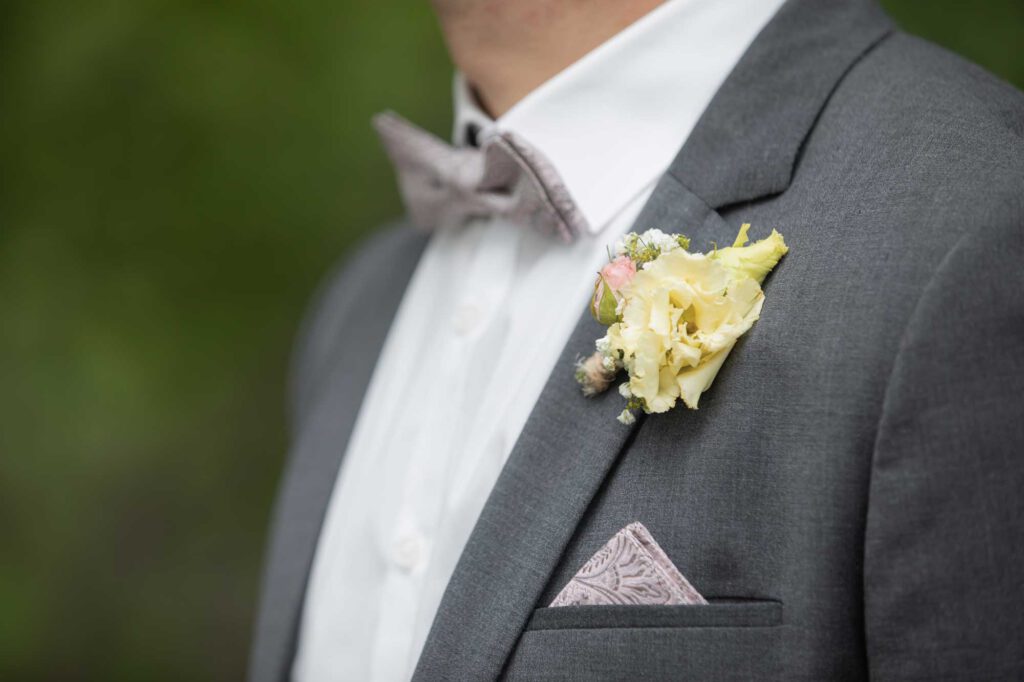 Detailaufnahmen vom Ehemann - Fliege, Anzug und Blumen