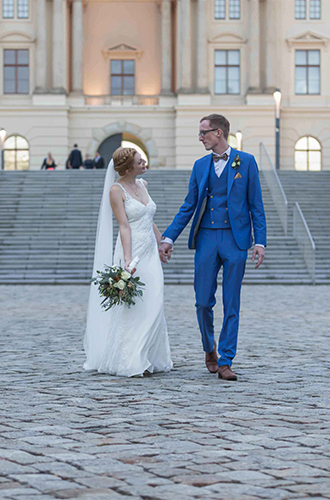 Jan Windisch, Hochzeitsfotograf aus Dresden, Leipzig, Chemnitz und Bautzen, fotografierte hier ein frisch getrautes Pärchen, das Hand in Hand vor einer Treppe steht und sich verliebt in die Augen schaut.